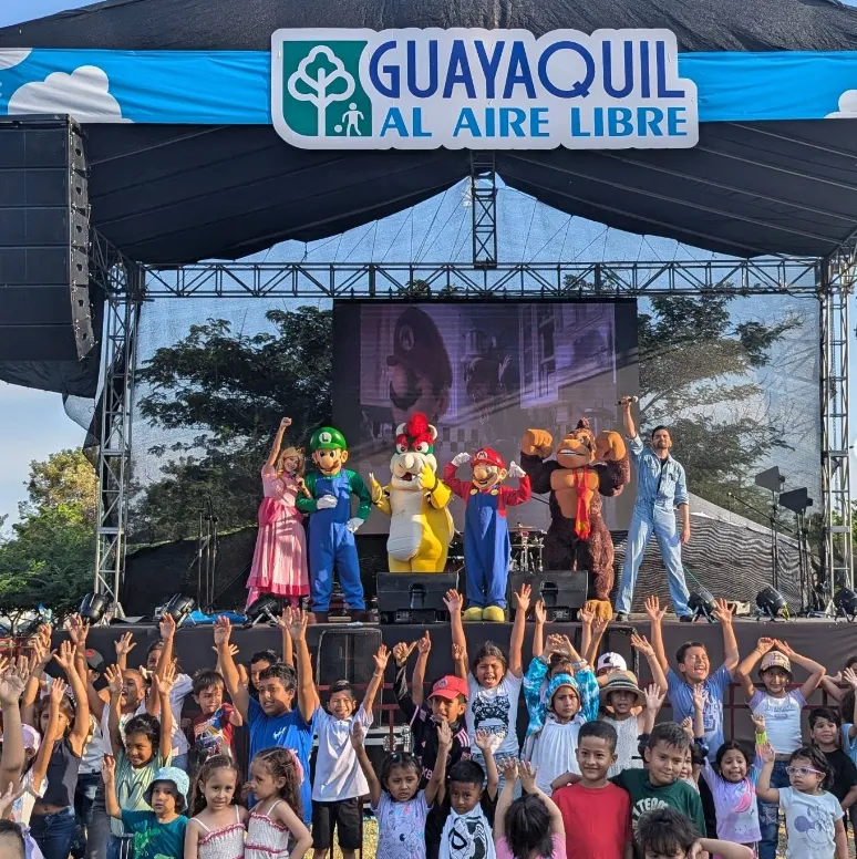 Show con personajes en tarima y público en el evento Guayaquil al Aire Libre